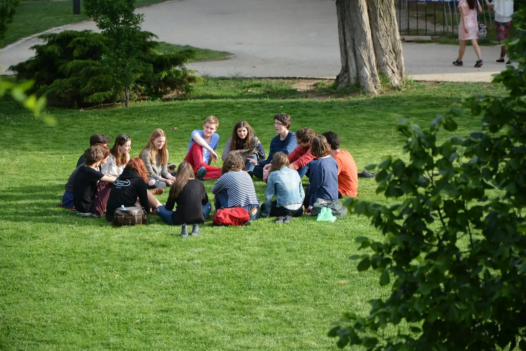 People sitting together in a circle on the grass