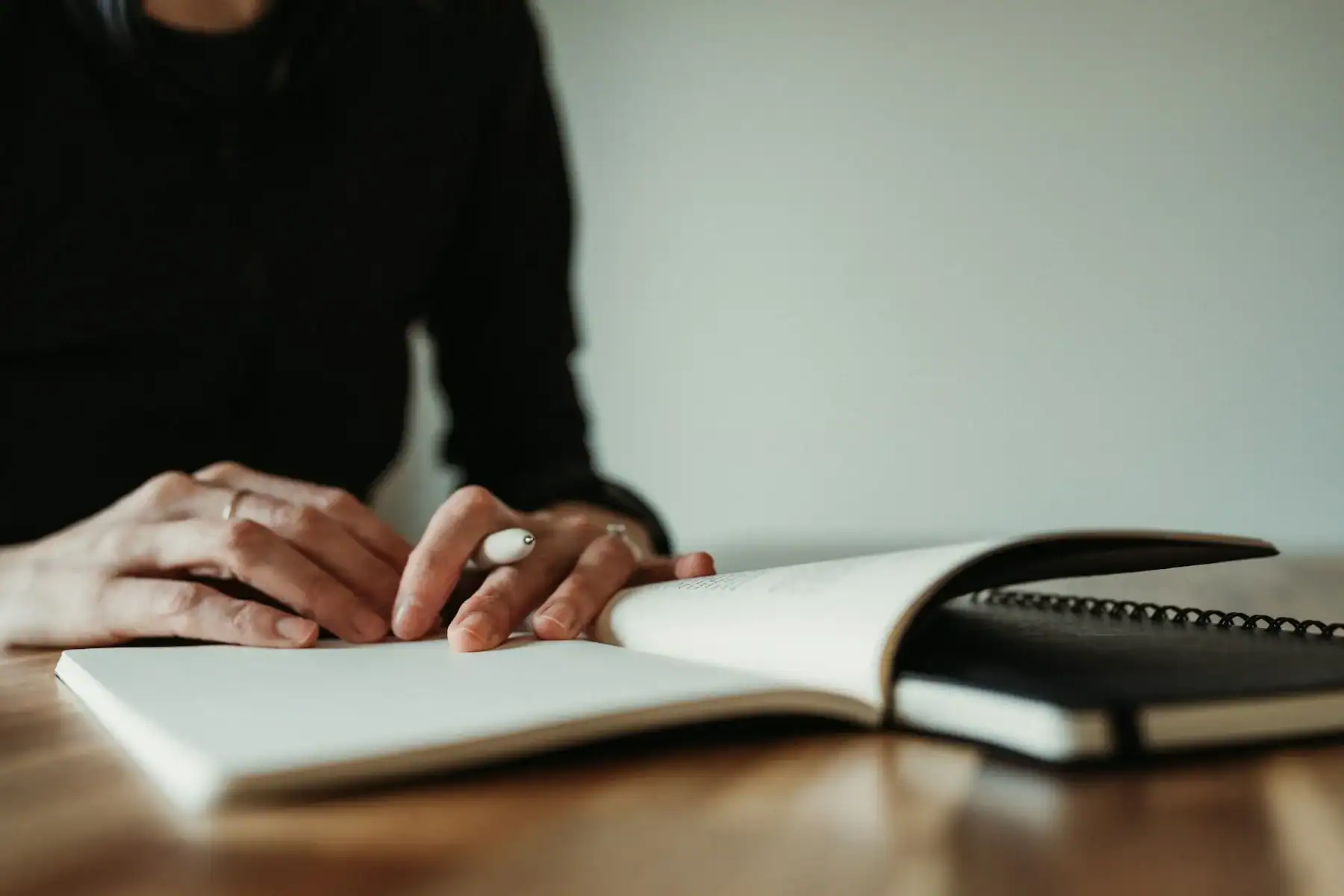 A person reading and writing at a table