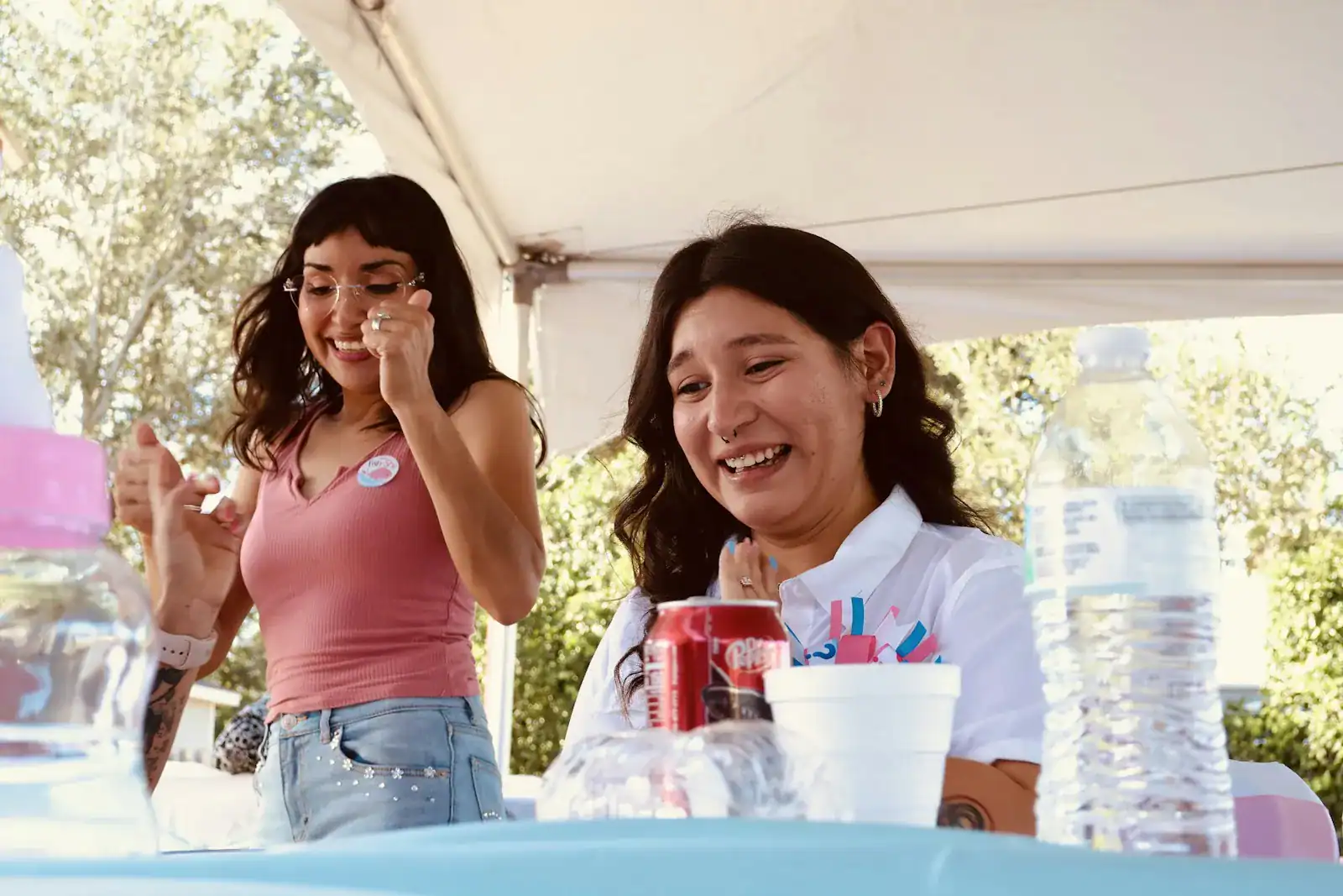 Two women smiling and talking at an outdoor table