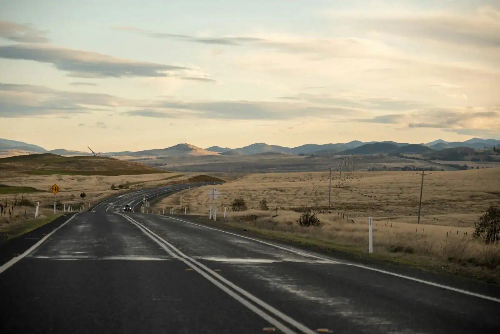 An open road winding through a broad rural landscape