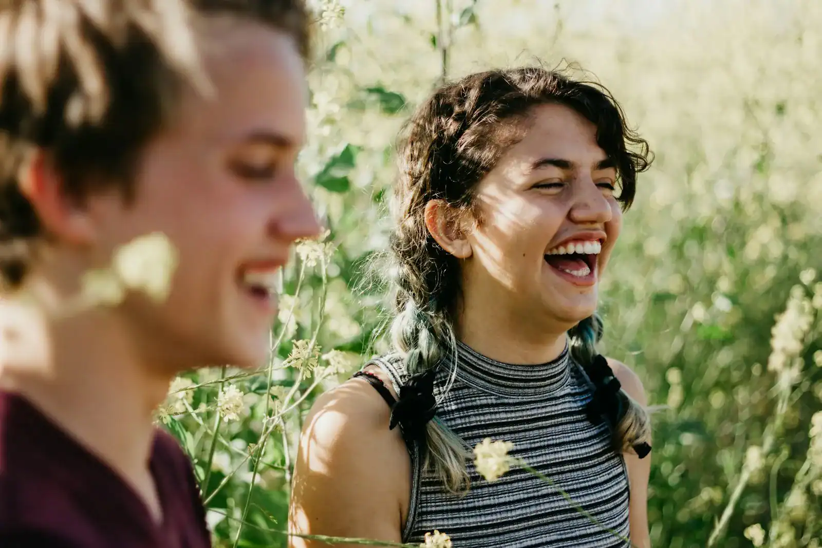 Two women laughing together outdoors in a garden