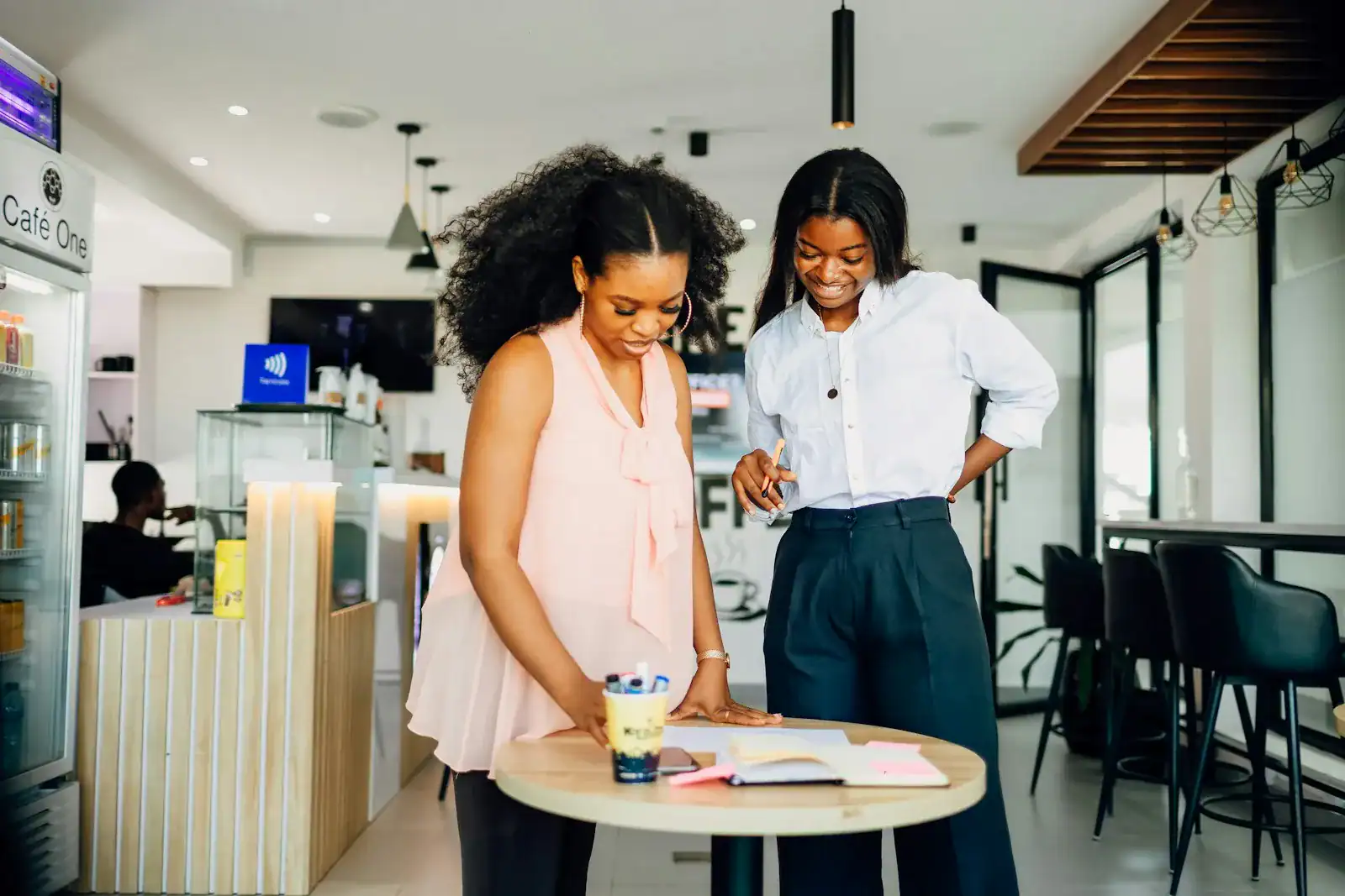 Two women working together at a small shop counter